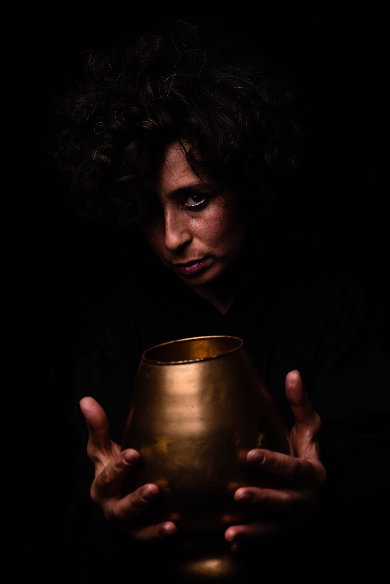 Retrato en penumbra de una mujer con un cuenco