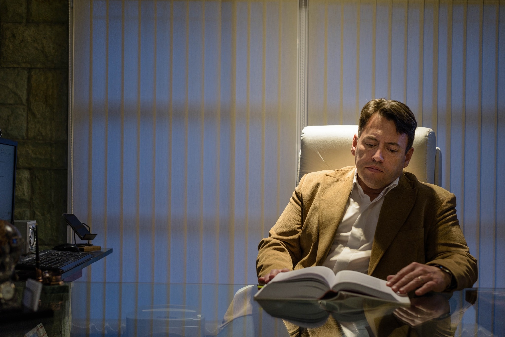 Hombre sentado leyendo junto a una ventana